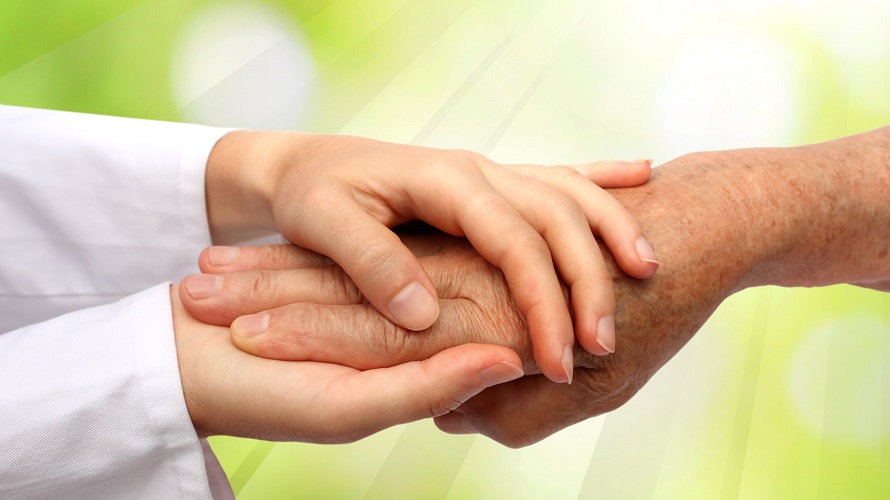 Frau umfasst die Hand eines älteren Menschen Frau umfasst die Hand eines älteren Menschen